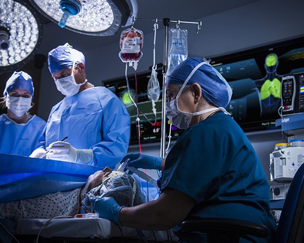 Des médecins opérant un patient avec le dispositif UniView à l'arrière-plan