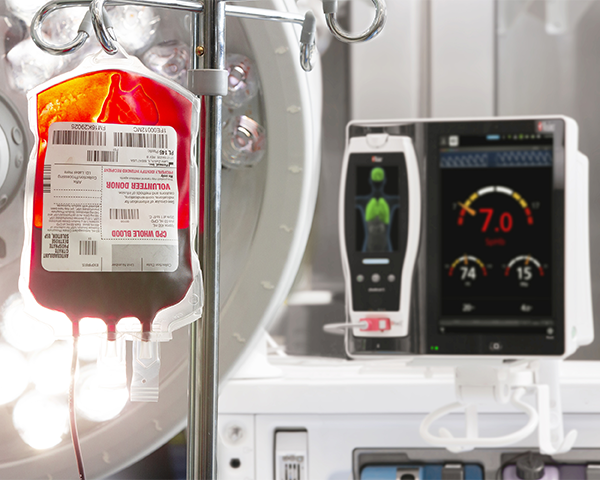 Poche de perfusion intraveineuse suspendue près du dispositif de surveillance au chevet du patient.
