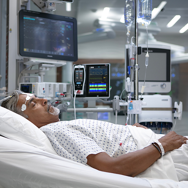 Patient hospitalisé utilisant des moniteurs et capteurs Masimo pour la surveillance continue des signes vitaux et de la fonction cérébrale.