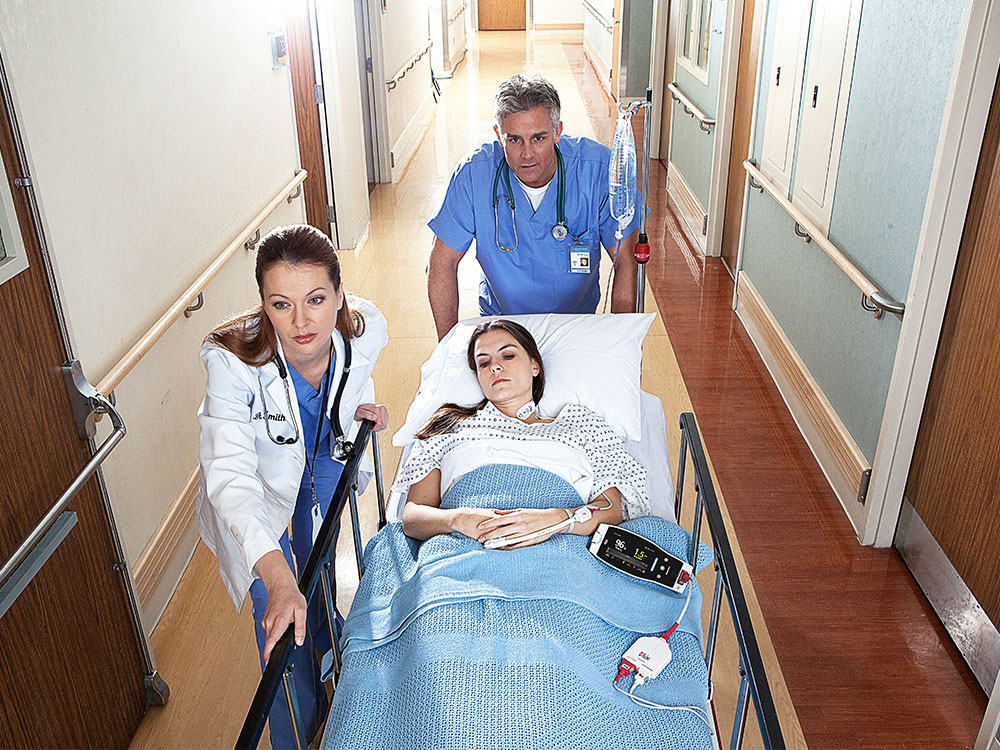 Masimo - Déplacement d’un patient dans un couloir avec le moniteur portable Radical-7