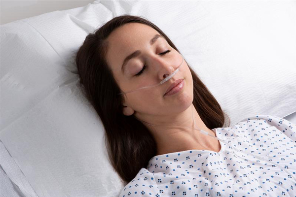 Masimo – Femme adulte dans un lit d'hôpital avec la ligne de capnographie RRc NomoLine